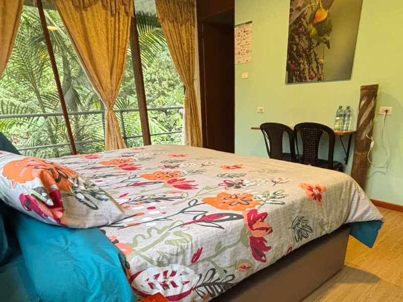 King Room at Mashpi Amagusa Lodge includes a king-sized bed, small table with chairs, and ample space for luggage.